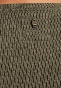 Olivgrünes gestricktes Kleidungsstück mit gerippter Textur. Verfügt über ein schwarzes und goldenes PME Legend-Logoetikett, das sich am oberen Rücken befindet.