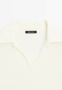 Bílá polo košile s klasickým límcem, která má měkkou texturu a štítek s nápisem "Massimo Dutti" černou barvou.