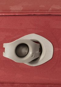 Rode stoffen reistas met een grijze, ronde ritshanger, voorzien van een gestructureerd oppervlak en een inset ronde opening voor een gemakkelijke grip.