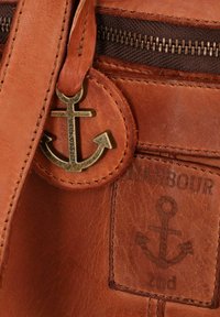 Borsa in pelle marrone con tasca con zip, logo dell'ancora in rilievo e un ciondolo a forma di ancora attaccato alla tracolla. Finitura testurizzata e dettagli di cucitura.