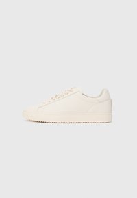 Low-top off-white sneaker with lace-up closure and ridged sole, shown in side profile on plain light background.