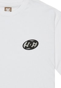 Biała bawełniana koszulka z małym czarnym owalnym logo z napisem "DC" i gwiazdką, umieszczonym na lewym obszarze klatki piersiowej. Okrągły dekolt.