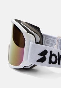 Skibril met een witte frame, paarse glazen en zwarte schuimrubberen voering. Voorzien van een verstelbare witte band met een logo.