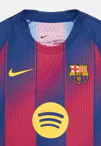 FC Barcelona-drakt i blå og røde striper. Inkluderer Nike-logo, klubbmerke og stor gul Spotify-logo. Laget av fukttransporterende stoff.