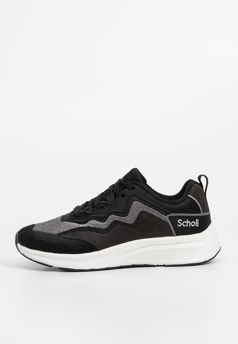Chaussure de sport noire et grise avec un dessus texturé, un design en zigzag contrasté et une semelle en caoutchouc blanche. Présente un logo "Scholl" sur le côté.