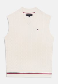 Pull en maille torsadée crème sans manches avec un col en V, doté d'un ourlet côtelé avec des accents de rayures rouges et bleues, et d'un petit logo sur la poitrine.