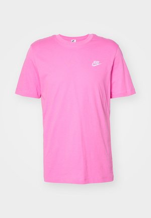 Camiseta de algodón rosa con mangas cortas y cuello redondo. Presenta un pequeño logo blanco de Nike en el lado izquierdo del pecho. Textura suave y diseño casual.