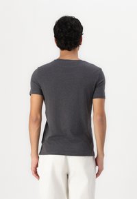 Tricou gri cu mânecă scurtă, cu un design clasic de guler tip crew, fabricat dintr-un material moale, având o textură simplă și netedă, cu un aspect discret.