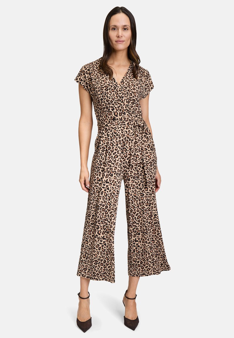 Overal s leopardím vzorom, krátkymi rukávmi, zaväzovaním a voľná široká noha. Vyrobený z jemného materiálu, s detailom zaväzovania v páse. Hnedé a béžové farby.