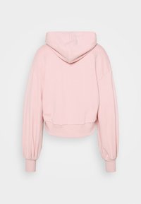 Sudadera corta rosa con una textura suave, que cuenta con una capucha, hombros caídos y puños y dobladillo acanalados. Diseño sencillo sin patrones visibles.