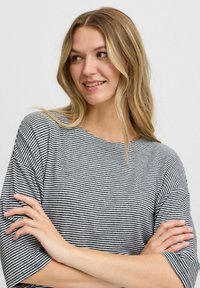 Gestreiftes Kurzarm-T-Shirt in Marineblau und Weiß, mit lockerer Passform und weichem, strukturiertem Stoff. Dezenter Bootsausschnitt und abgesenkte Schultern.