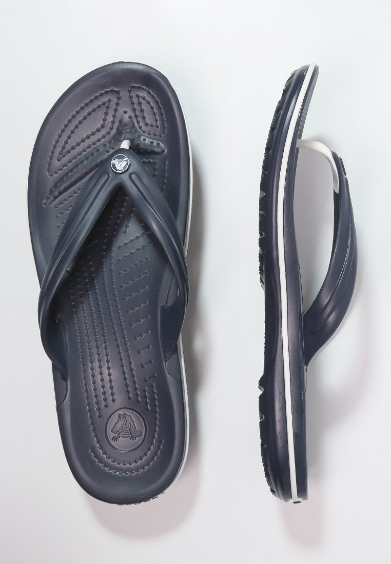 Chanclas de color azul marino hechas de goma con una base texturizada, un acento blanco a lo largo de la suela y un logo en la plantilla.