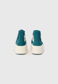 Türkise Canvas-Hochtop-Sneaker mit weißen Gummisohlen, die runde Logopatches an jeder Außenseite und eine strukturierte Oberfläche aufweisen.