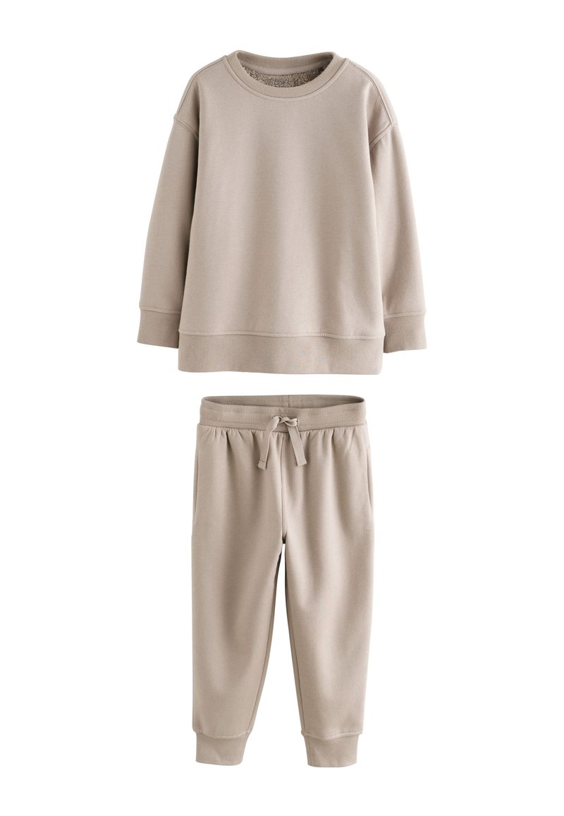 Beige cotton sweatshirt with round neckline, ribbed cuffs, and matching tapered sweatpants with drawstring waist and side pockets.