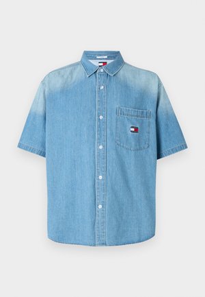 Hele sinine lühikeste varrukatega denim särk krae, esikott ja nööpidega kinnitamine. Kotil on logo plaastriga.