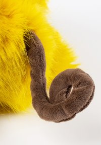 Yellow fluffy object with a soft, brown, curled tail-like appendage against a plain white background.