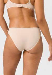 Beige Damenunterwäsche mit glatter, weicher Textur und klassischem Slip-Schnitt. Verfügt über einen dünnen elastischen Bund und nahtlose Kanten.