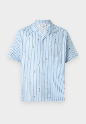 Lys blå kortermet skjorte med knapper, tynne vertikale svarte striper og små gjentatte krokodillelogoer, åpen krage og fremre lomme.