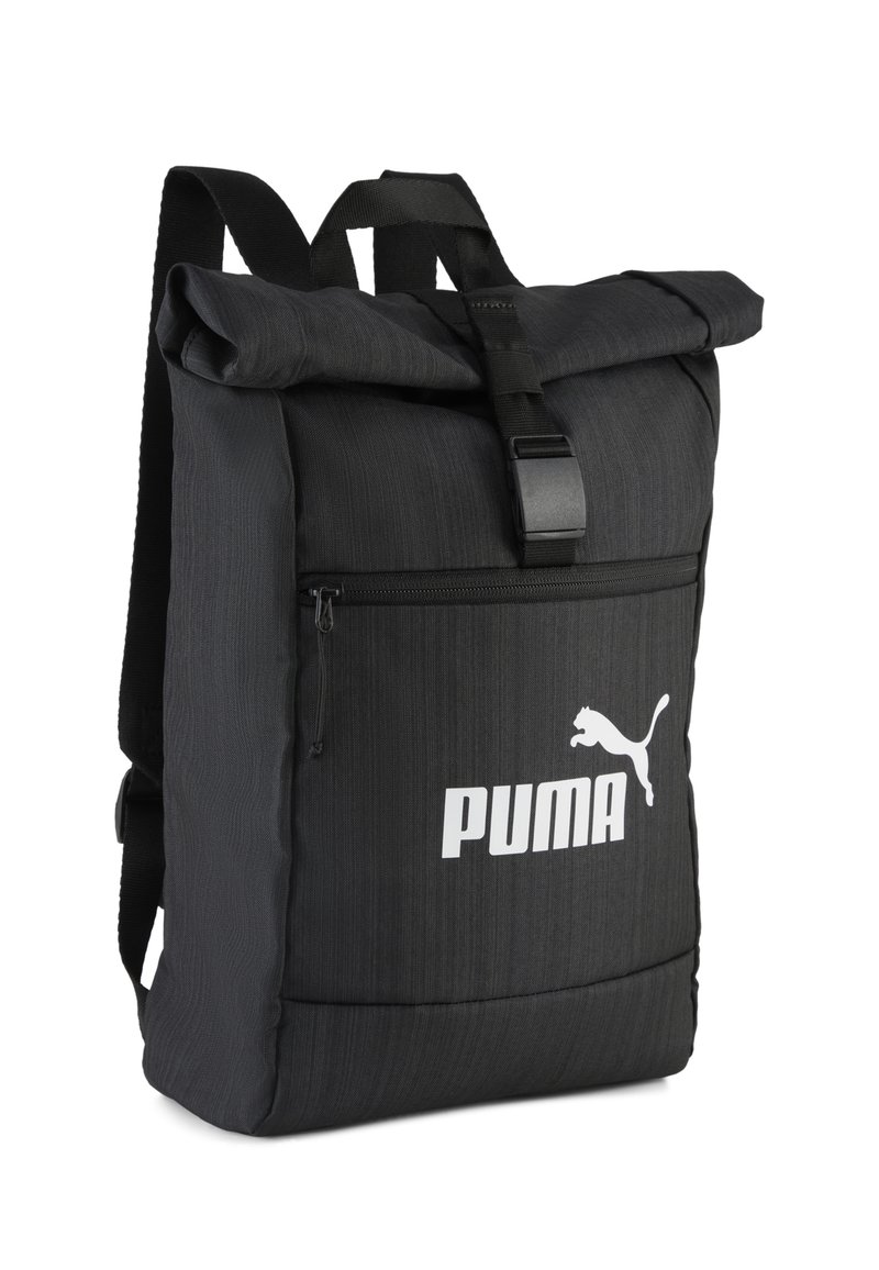 Sac à dos noir à rabat enroulable en tissu texturé, doté d'une poche zippée à l'avant et d'un logo blanc. Sangles ajustables et fermeture à boucle robuste.