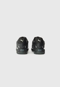 Zapatillas deportivas negras con un upper texturizado, que cuentan con un acolchado en el collar y el talón, acentos reflectantes y una suela de goma duradera.