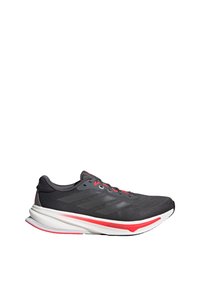Black athletic shoe with a textured fabric upper, grey accents, red laces, and a white sole featuring a red detail on the side.