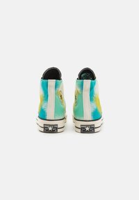 Wysokie sneakersy z gradientowym wzorem w odcieniach niebieskiego, zielonego i żółtego, białymi akcentami oraz czarną podeszwą z logo.