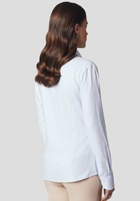 Jasnoniebieska koszula w paski, wykonana z lekkiego materiału, z długimi rękawami, klasycznym kołnierzykiem i mankietami zapinanymi na guziki o gładkiej teksturze.