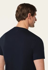 Navyblauw T-shirt met korte mouwen en een ronde hals, gemaakt van een soepele katoenmix. Subtiele logodetail nabij de hals.