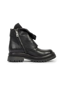 Bottine noire en cuir avec semelle épaisse à crampons, fermeture éclair latérale et grand rabat en cuir plié sur le devant et les côtés.