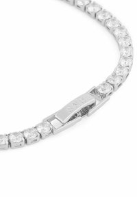 Silverfärgad armband med runda, klara kristaller i en länkad design, med ett säkert lås som är märkt med varumärkesnamnet.