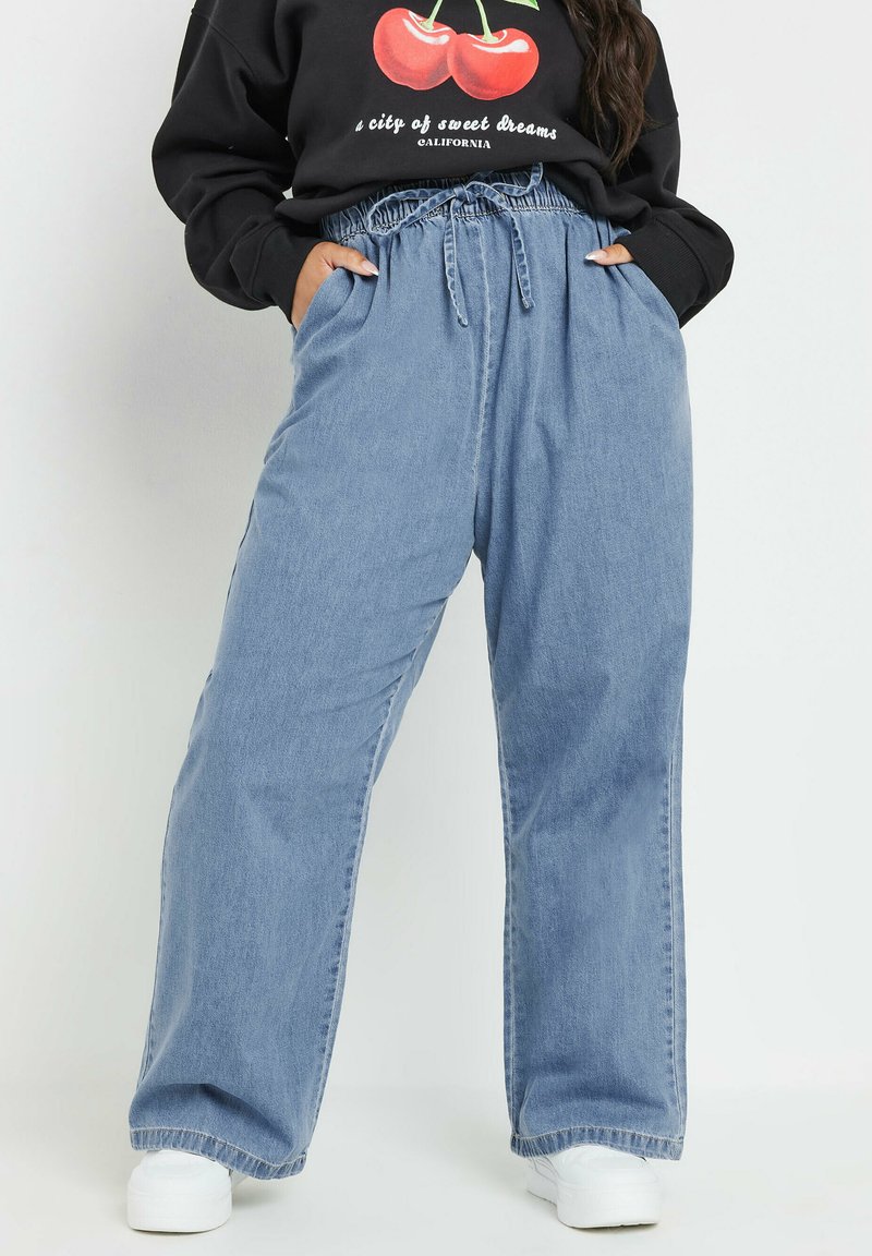 Ljusblå denim joggerbyxor med elastisk midja, snörningsdetalj och sidofickor. Avslappnad passform med bred ben-design och upprullade fållar.