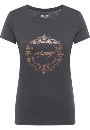 Camiseta de manga corta de color gris oscuro con cuello redondo, que presenta un patrón geométrico en cobre y el texto "Mustang 1932" en el centro.