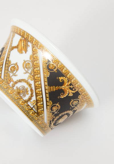 Fényes fehér belsejű kerámia tál, részletes arany és fekete mintákkal, díszítésekkel és motívumokkal.