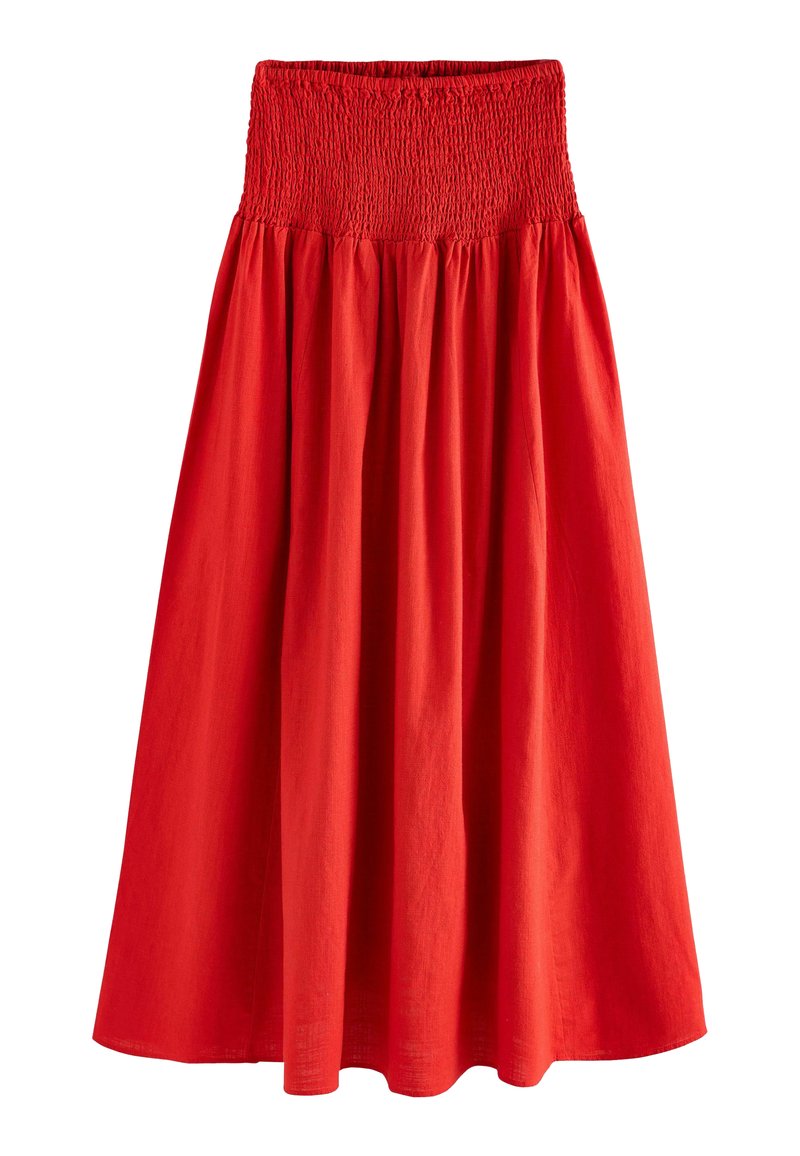 Jupe en coton rouge présentant une taille smockée et une silhouette évasée. Le tissu a une texture lisse et un éclat subtil.