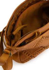 Braune Leder-Crossbody-Tasche mit perforierten Details, einem Reißverschluss-Hauptfach und einer geflochtenen Textur auf einer Seite.