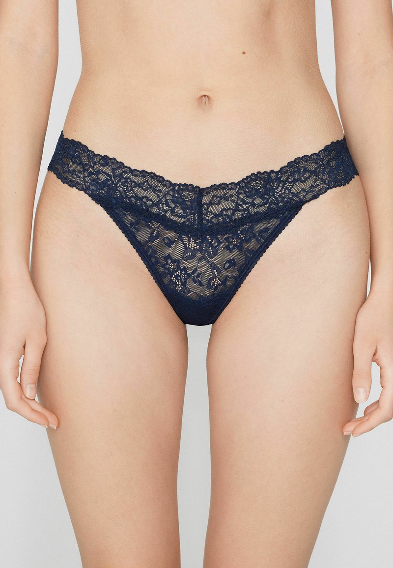 Marineblauer Spitzen-String mit floralem Muster, verziert mit einer zarten Spitzenborte an der Taille und einer weichen, transparenten Textur.