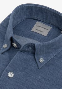 Camisa azul de botones hecha de tela texturizada. Presenta un cuello clásico, dos botones frontales y una etiqueta interna que dice "DAN JOHN REGULAR".