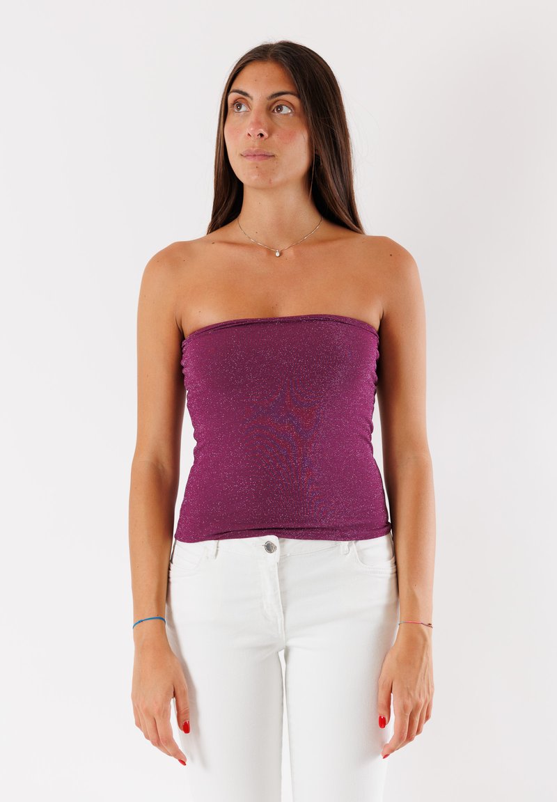 Top senza spalle bordeaux con design aderente, lucentezza texture e tessuto morbido. Abbinato a pantaloni bianchi per creare contrasto.