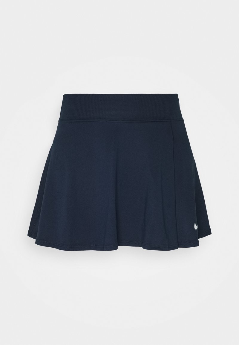 Falda corta deportiva de color azul marino con una cinturilla ancha y pequeño logo blanco de Nike cerca del dobladillo en el lado derecho.