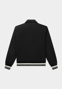 Giacca nera con collo a camicia, polsini e fascia in vita a coste, caratterizzati da strisce bianche e beige. Tessuto liscio con una silhouette aderente.