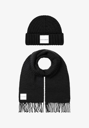 Musthave õmmeldud beanie ja sall komplekt. Sallil on fringi otstes; mõlemal on tekstureeritud muster koos valge logo sildiga.