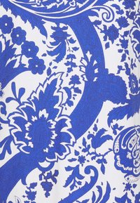 Blå blommönster och paisleymönster på vit tyg, med intrikata detaljer och varierande nyanser av blått samt en slät textur.