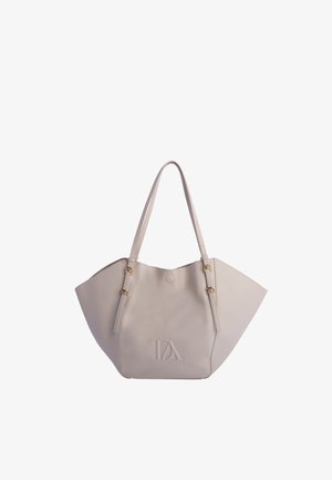 Bolso tote de piel beige con correas de hombro ajustables, hebillas doradas y logo "DA" en relieve en el centro frontal.