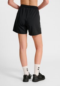 Svarta sportshorts med elastisk midja och sidofickor. Har en smidig, lätt textur och ett logotypaccent på sidan.