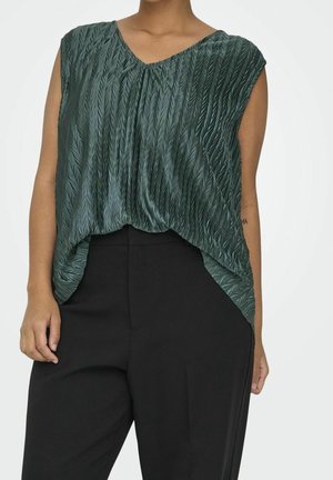 Sleeveless green textured top with a V-neck paired with high-waisted black trousers on a standing person.