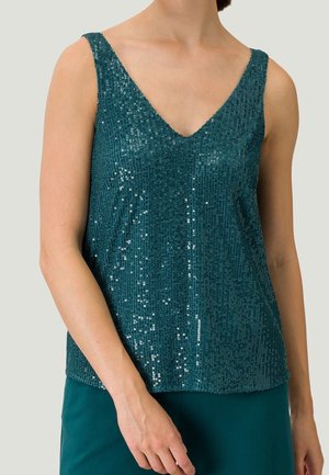Tealowa kamizelka z cekinami o dekolcie w kształcie litery V, bez rękawów, z teksturowanej tkaniny i lśniących akcentów, podkreślających jej refleksyjny charakter.