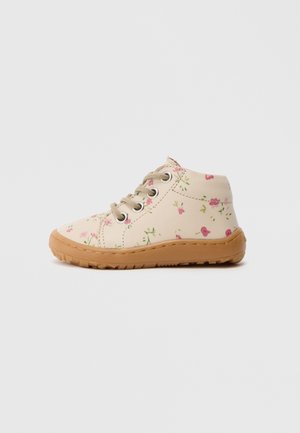 Floral-patterned high-top shoes in cream with pink and green details, tan rubber sole, and metal eyelets for laces.
