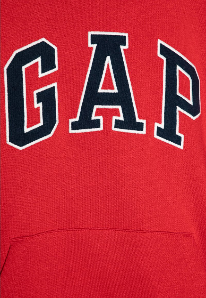 Roter Hoodie mit dem Wort "GAP" in fetten, marineblauen Buchstaben mit weißer Umrandung und einer Kängurutasche an der Vorderseite.