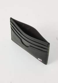 Black leather cardholder featuring textured exterior, six card slots, and a logo accent. Compact shape with open top design.