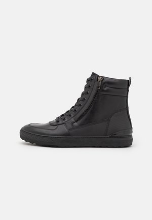 Sort højhalset sneaker med sidelås, snørebånd foran, tekstureret sål og polstret ankelkrave.